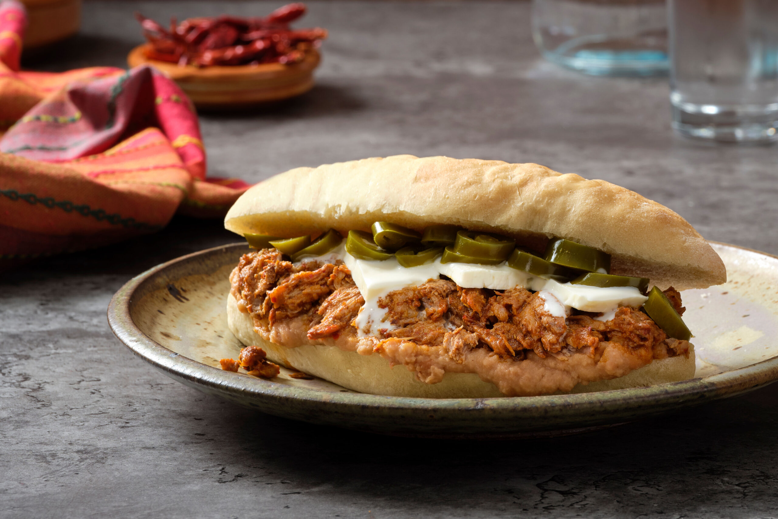 Chile Charred Pork Sandwich with Panela Cheese, Crema and Pickled Jalapeños